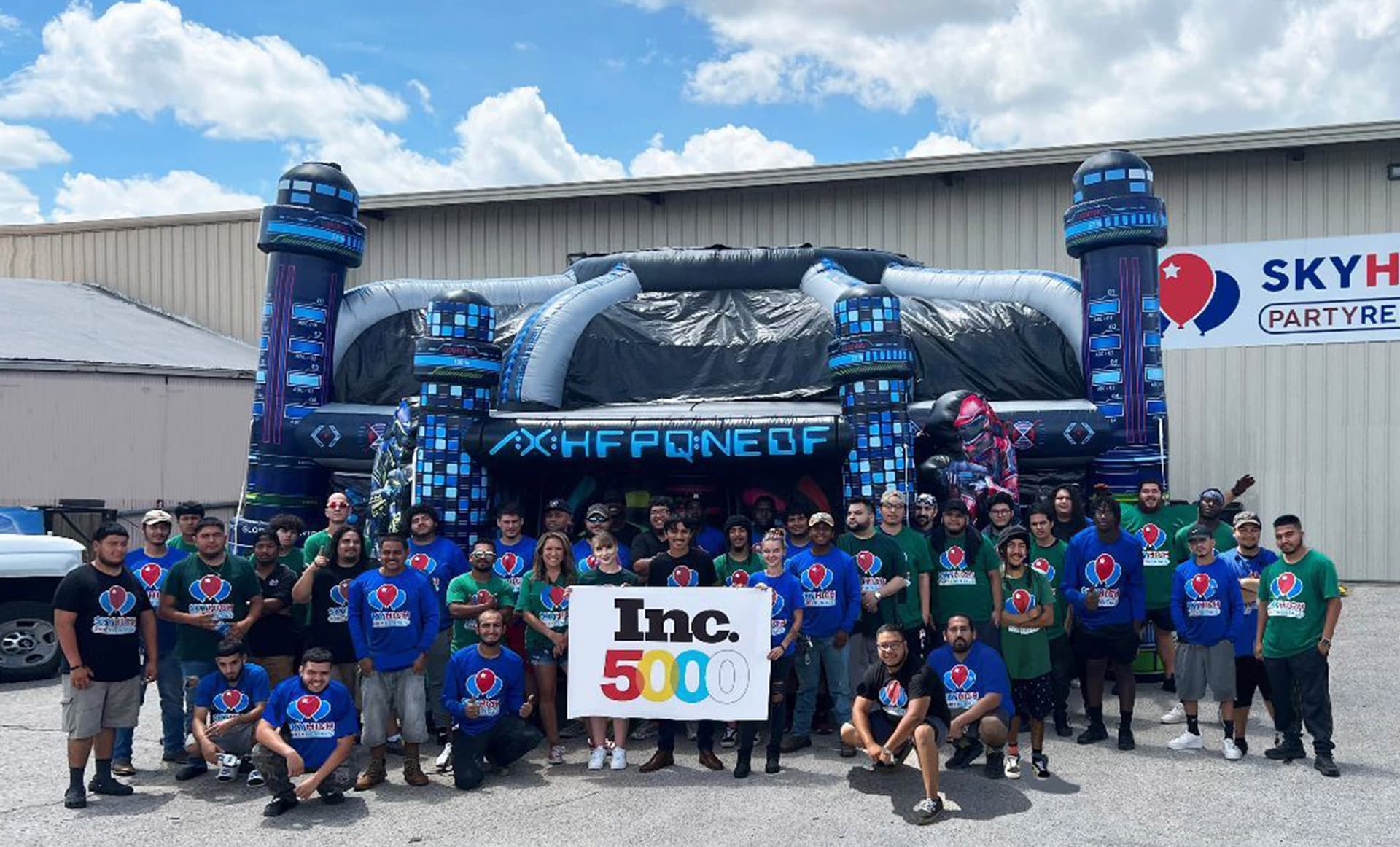 The Sky High Party Rentals crew holding an Inc. 5000 sign in front of the warehouse